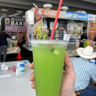 a hand holding a green drink