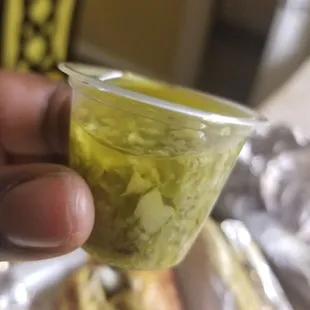 a hand holding a cup of pickle