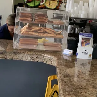 a counter with hot dogs and coffee