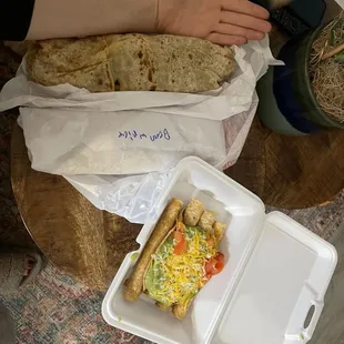 a person holding a sandwich in a styrofoam container