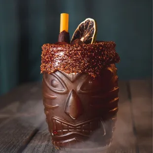a chocolate tiki with a slice of orange