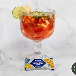 a glass of salsa with a lime slice
