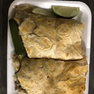 two burritos in a styrofoam container