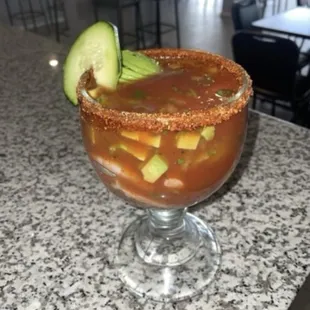 a bloody drink with a cucumber garnish