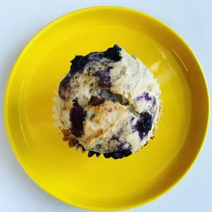 a blueberry muffin on a yellow plate