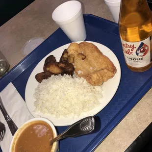 White rice, sweet plantains, fried fish and a cup of red beans. To drink, meregue flavored country club soda.
