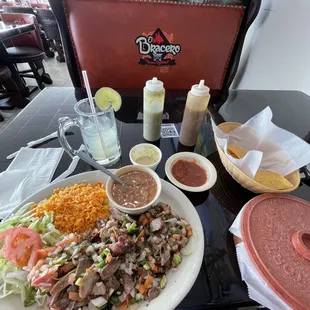 Carnitas plate (la Mexicana) with charro beans, margarita on the rocks, and fantastic salsa options.