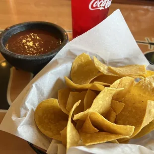 a bowl of chips and a drink