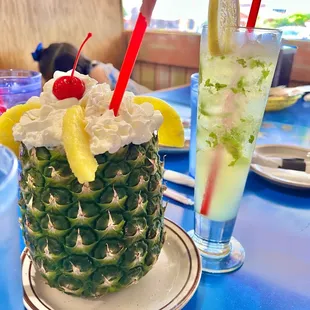 a pineapple with whipped cream and a cherry on top