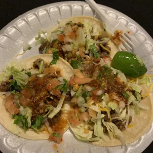 two tacos on a paper plate