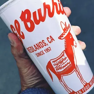 a hand holding a paper cup