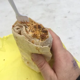 a hand holding a burrito
