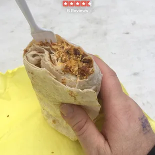 a hand holding a burrito