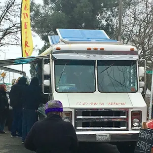 a line of people waiting in line at a food truck