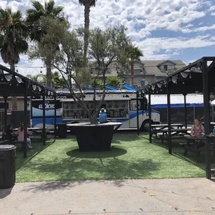 Food truck courtyard with shade and picnic benches