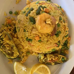 a plate of rice with shrimp and vegetables