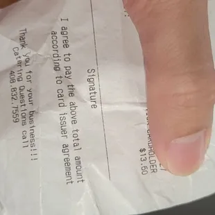 a hand holding a receipt