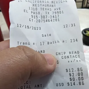 a hand holding a receipt