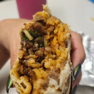 a hand holding a burrito