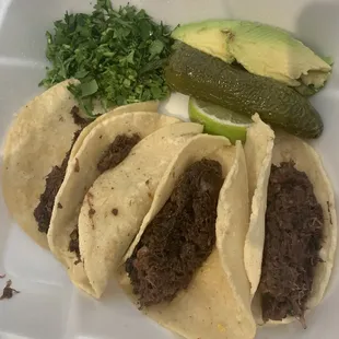 three tacos in a styrofoam container