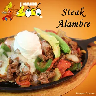 Our Steak Alambre is a skillet with sliced green and red bell peppers, jalapenos, onions, bacon and ham; topped with melted cheese &amp; more.