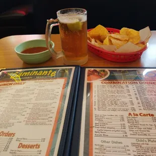 a menu and a drink on a table