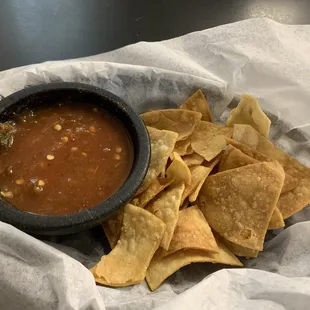 a bowl of salsa and tortillas