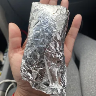  a hand holding a piece of aluminum foil
