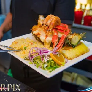 Mixed seafood served in a pineapple served with a generous portion of rice, beans and house salad.