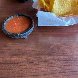 a table with chips and salsa