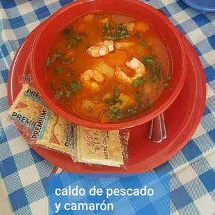 a bowl of seafood soup with crackers