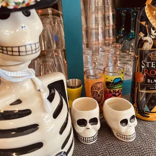 a skeleton with a sombren and a bottle of tequila