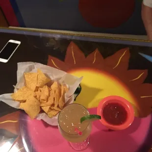a table with chips and salsa