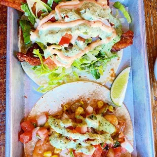 two tacos on a tray with a side salad