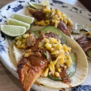 two fish tacos with corn and avocado