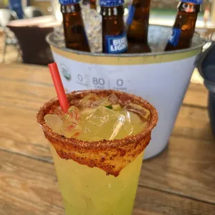 a glass of beer with a garnish on the rim