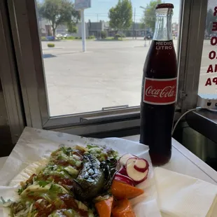 a bottle of coke and a plate of food