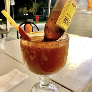 Super Michelada with a straw wrapped in tamarindo