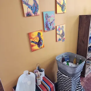 Water and beverages next to more artwork.