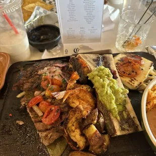 Steak with shrimp and potato and avocado with cheese and rice and beans