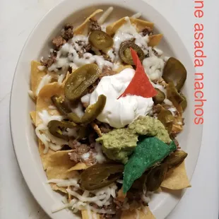 Carne asada nachos. Comes with cheese, beans, jalapeños, sour cream, and guacamole.