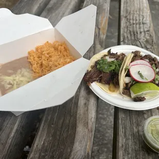 Birria and asada tacos with a side of rice and beans.