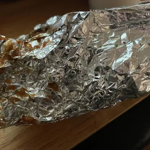 Food bits on the outside near the top where it is wrapped.  They wrapped this knowing it burst.