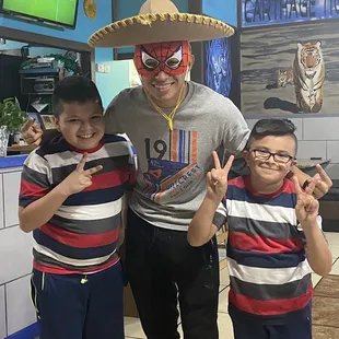 a man in a sombren and two boys in striped shirts