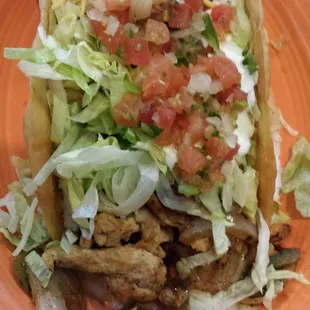 a taco with lettuce, tomatoes and cheese