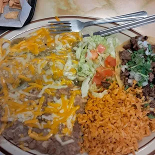 Combination Plate, enchilada, tamale, taco, fresh refried beans, and rice.