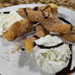 a desert with whipped cream and chocolate sauce
