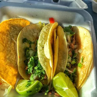 three tacos in a styrofoam container
