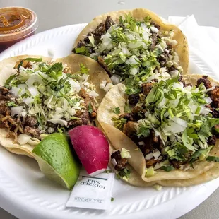 three tacos on a paper plate