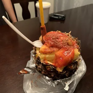 a pineapple topped with sauce and a fork